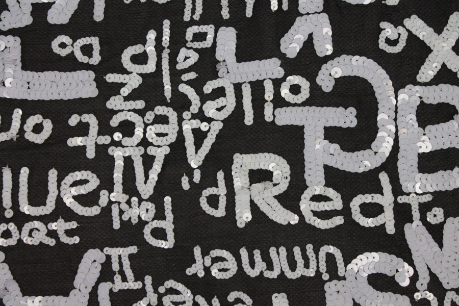 Black chiffon with white round sequin lettering fabric
